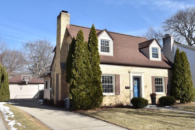 new england style home with a garage and a front lawn