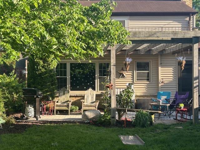 back of property with a pergola, a lawn, and a patio