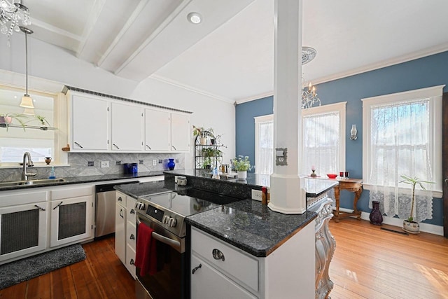 kitchen with sink, appliances with stainless steel finishes, a center island, tasteful backsplash, and white cabinets