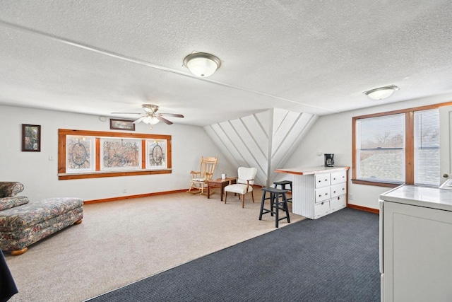 interior space featuring a textured ceiling, vaulted ceiling, and ceiling fan