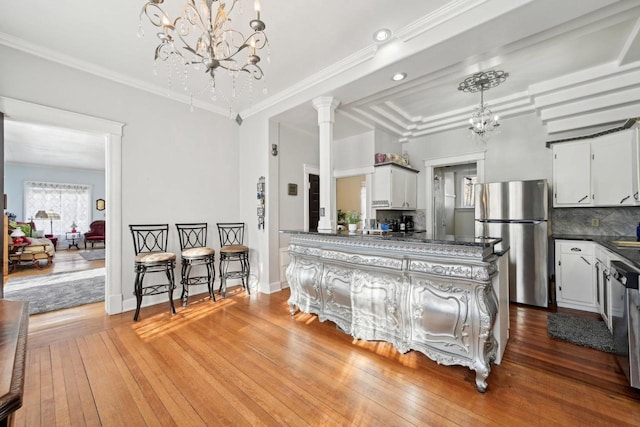 kitchen with white cabinetry, backsplash, hardwood / wood-style floors, and appliances with stainless steel finishes