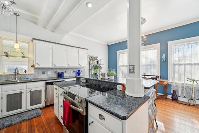 kitchen with sink, tasteful backsplash, a kitchen island, stainless steel appliances, and white cabinets