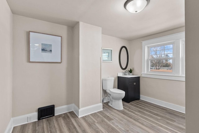 bathroom featuring vanity, toilet, and hardwood / wood-style floors