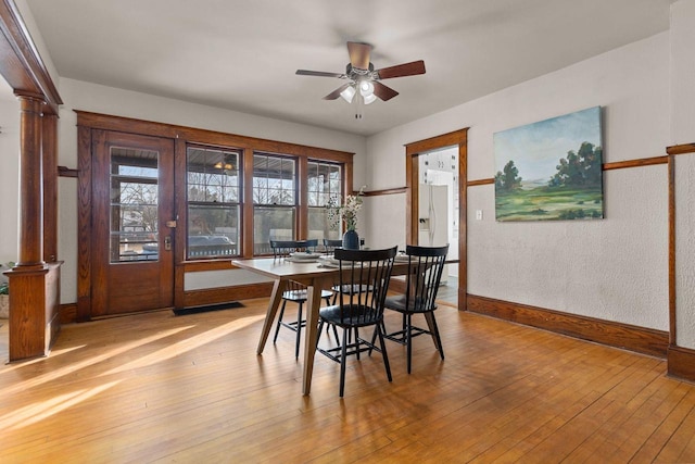 dining area featuring ceiling fan, light hardwood / wood-style floors, and ornate columns