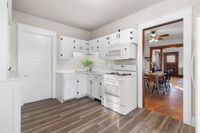 kitchen with sink, white cabinets, dark hardwood / wood-style flooring, decorative backsplash, and white appliances