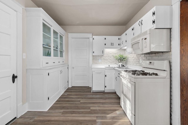 kitchen featuring sink, white appliances, dark hardwood / wood-style floors, tasteful backsplash, and white cabinets