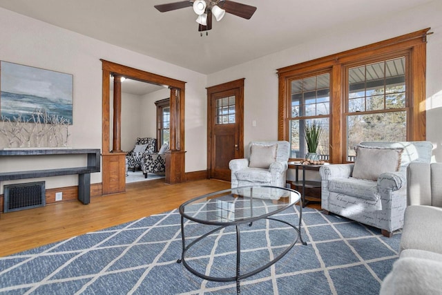 living room featuring wood-type flooring and ceiling fan