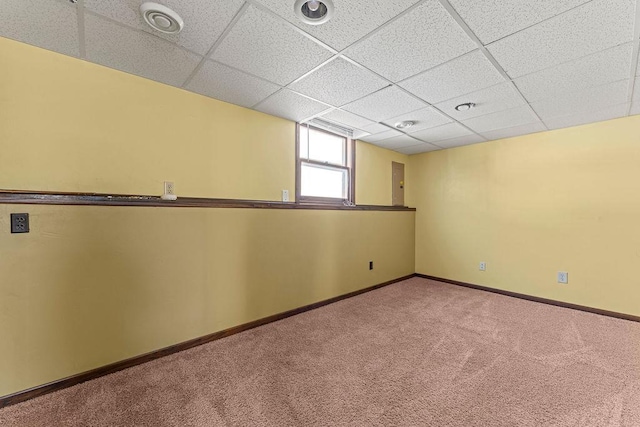 carpeted empty room with a paneled ceiling