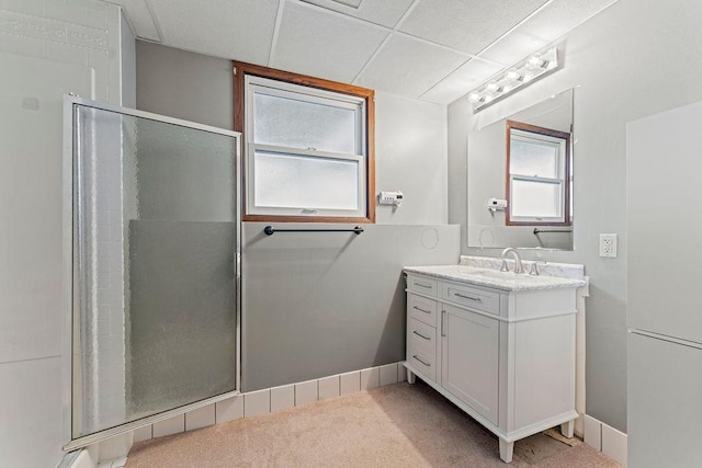 bathroom with vanity, a drop ceiling, and walk in shower