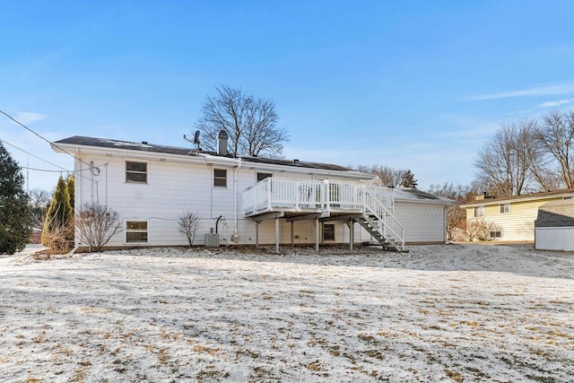 snow covered rear of property featuring cooling unit and a deck