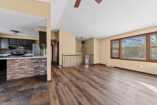 unfurnished living room with dark hardwood / wood-style flooring and ceiling fan