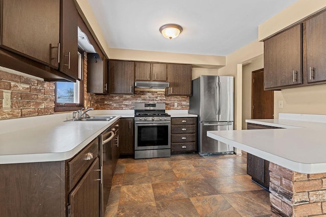 kitchen with dark brown cabinetry, sink, tasteful backsplash, and appliances with stainless steel finishes