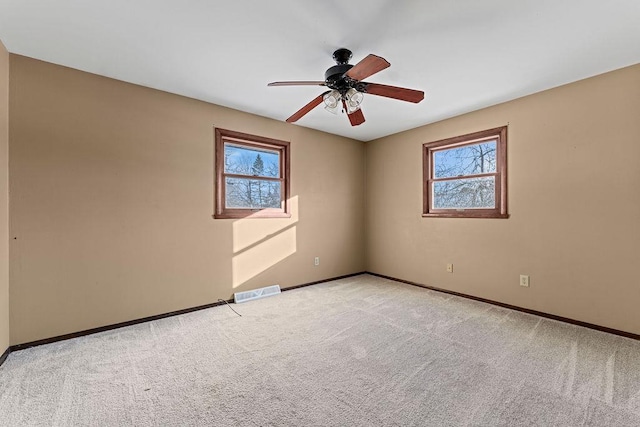 carpeted empty room featuring plenty of natural light and ceiling fan