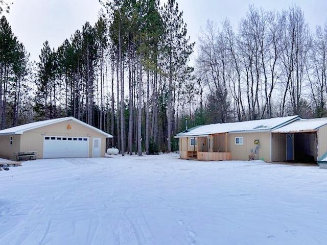 exterior space with a garage and an outbuilding