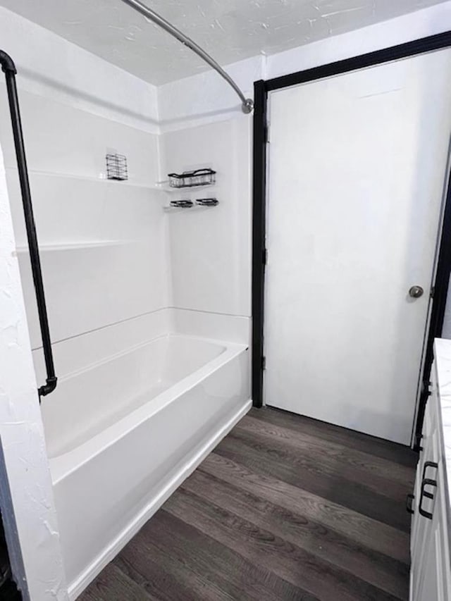 bathroom with hardwood / wood-style flooring and  shower combination