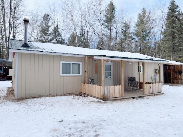 view of snow covered back of property