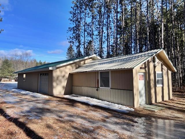 view of side of home with metal roof and a garage