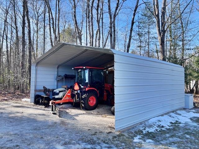 snow covered structure featuring a carport