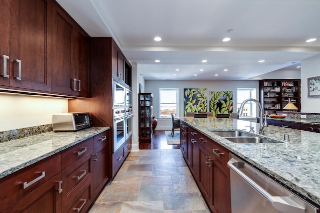 kitchen featuring light stone counters, appliances with stainless steel finishes, and sink