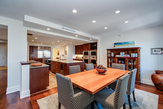 dining room featuring sink and dark hardwood / wood-style floors