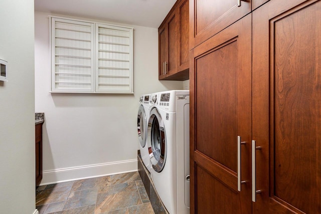 clothes washing area featuring cabinets and separate washer and dryer