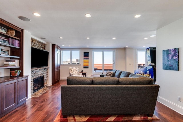 living room featuring a fireplace, dark hardwood / wood-style floors, and a wealth of natural light