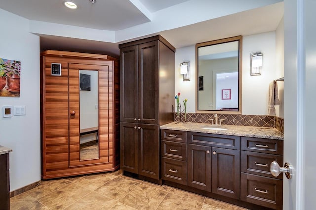 bathroom featuring vanity and backsplash