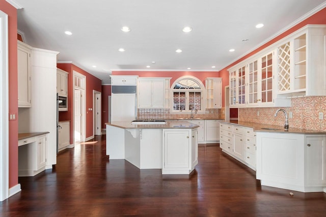 kitchen featuring a center island, sink, decorative backsplash, and paneled built in refrigerator