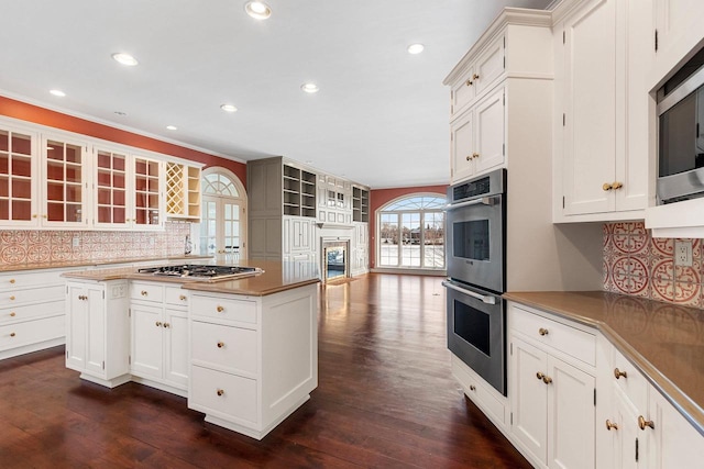 kitchen featuring tasteful backsplash, stainless steel appliances, and white cabinets