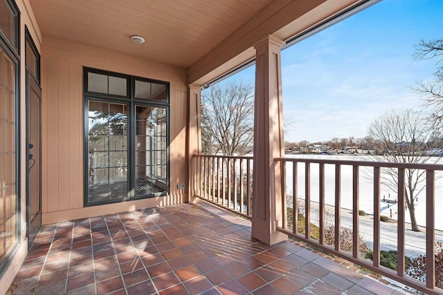 snow covered patio featuring a balcony