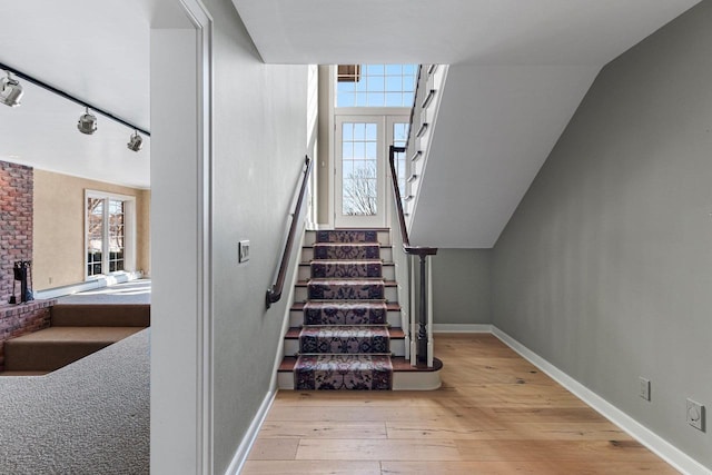 stairs featuring lofted ceiling and wood-type flooring