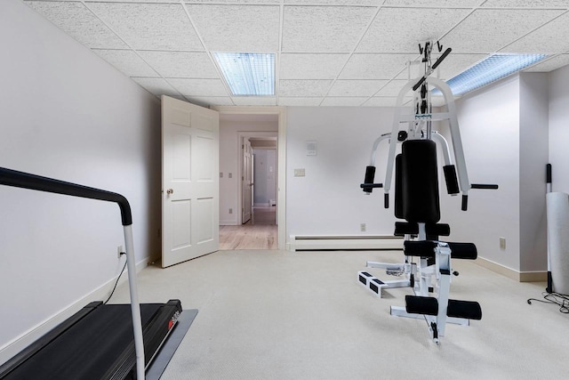 exercise room featuring carpet and a baseboard heating unit