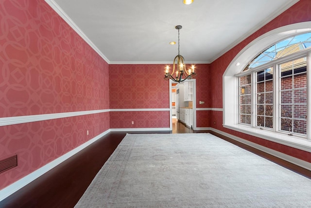 unfurnished dining area with crown molding, dark wood-type flooring, and a notable chandelier