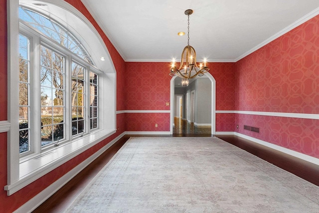 unfurnished dining area featuring ornamental molding and a chandelier