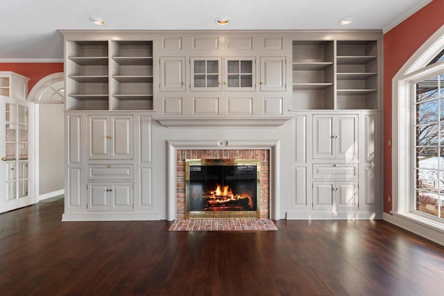 unfurnished living room featuring dark hardwood / wood-style floors, a healthy amount of sunlight, and a fireplace