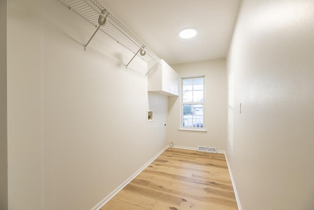 laundry area featuring hookup for a washing machine and light hardwood / wood-style flooring