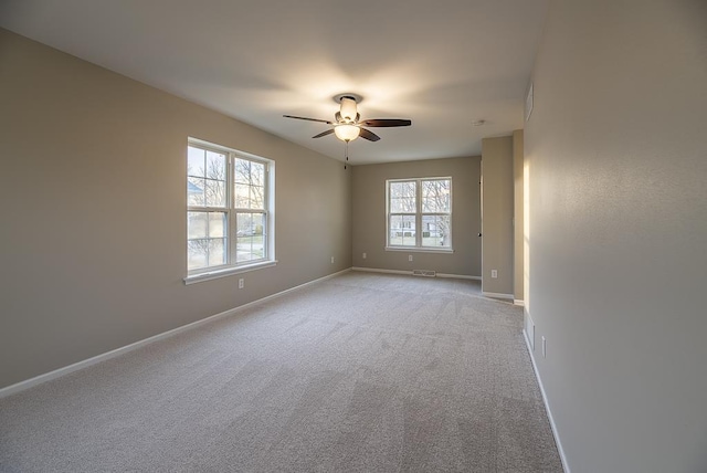 carpeted spare room with plenty of natural light and ceiling fan