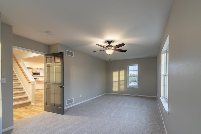 unfurnished room with carpet floors and ceiling fan