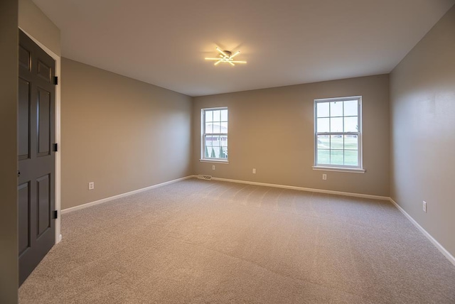 unfurnished room featuring light carpet