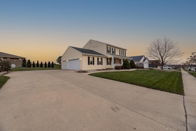 view of front of property with a garage and a lawn