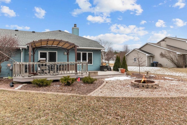 back of house with a wooden deck and an outdoor fire pit