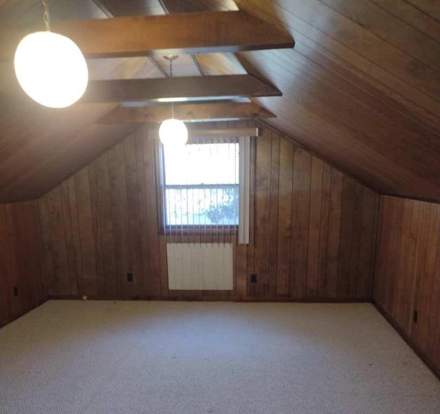 bonus room featuring light carpet, radiator heating unit, wooden walls, and lofted ceiling with beams