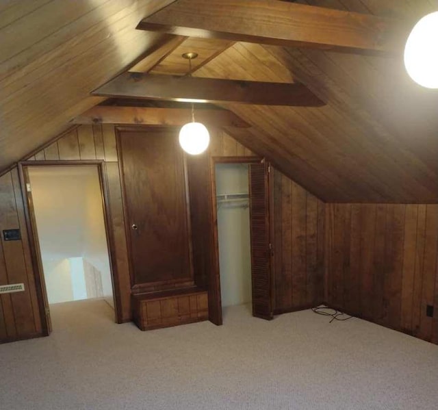 bonus room with light carpet, vaulted ceiling with beams, wood ceiling, and wooden walls