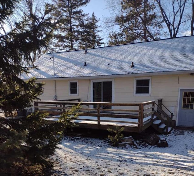 snow covered rear of property featuring a deck