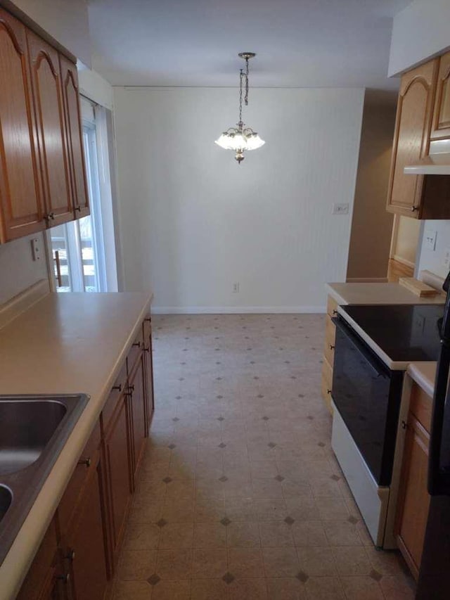 kitchen with pendant lighting, sink, range with electric cooktop, and a chandelier