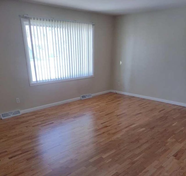 empty room with hardwood / wood-style flooring