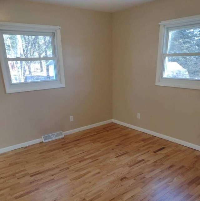 unfurnished room featuring light hardwood / wood-style flooring and plenty of natural light