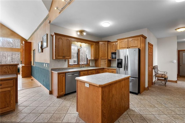 kitchen with light tile patterned flooring, lofted ceiling, sink, a center island, and appliances with stainless steel finishes