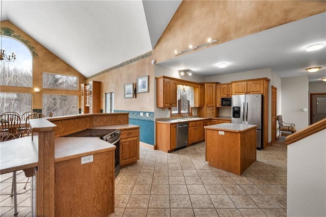 kitchen with appliances with stainless steel finishes, high vaulted ceiling, a center island, a kitchen bar, and light tile patterned flooring