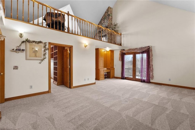 unfurnished room with light colored carpet, high vaulted ceiling, and french doors